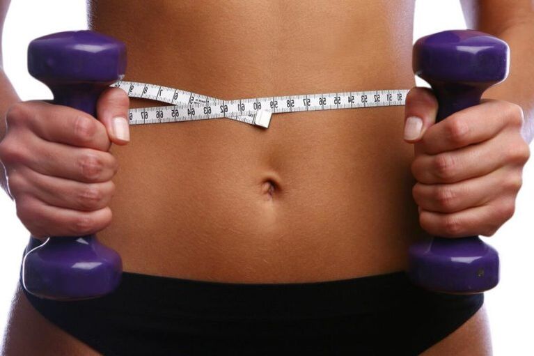 Fitnesz súlyzók egy megfelelő lány kezében